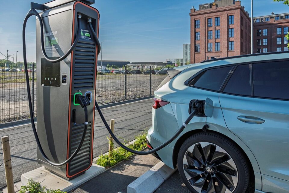 Modern electric vehicles charging at a public fast-charging station in Europe during the 2026 EV sales surge.